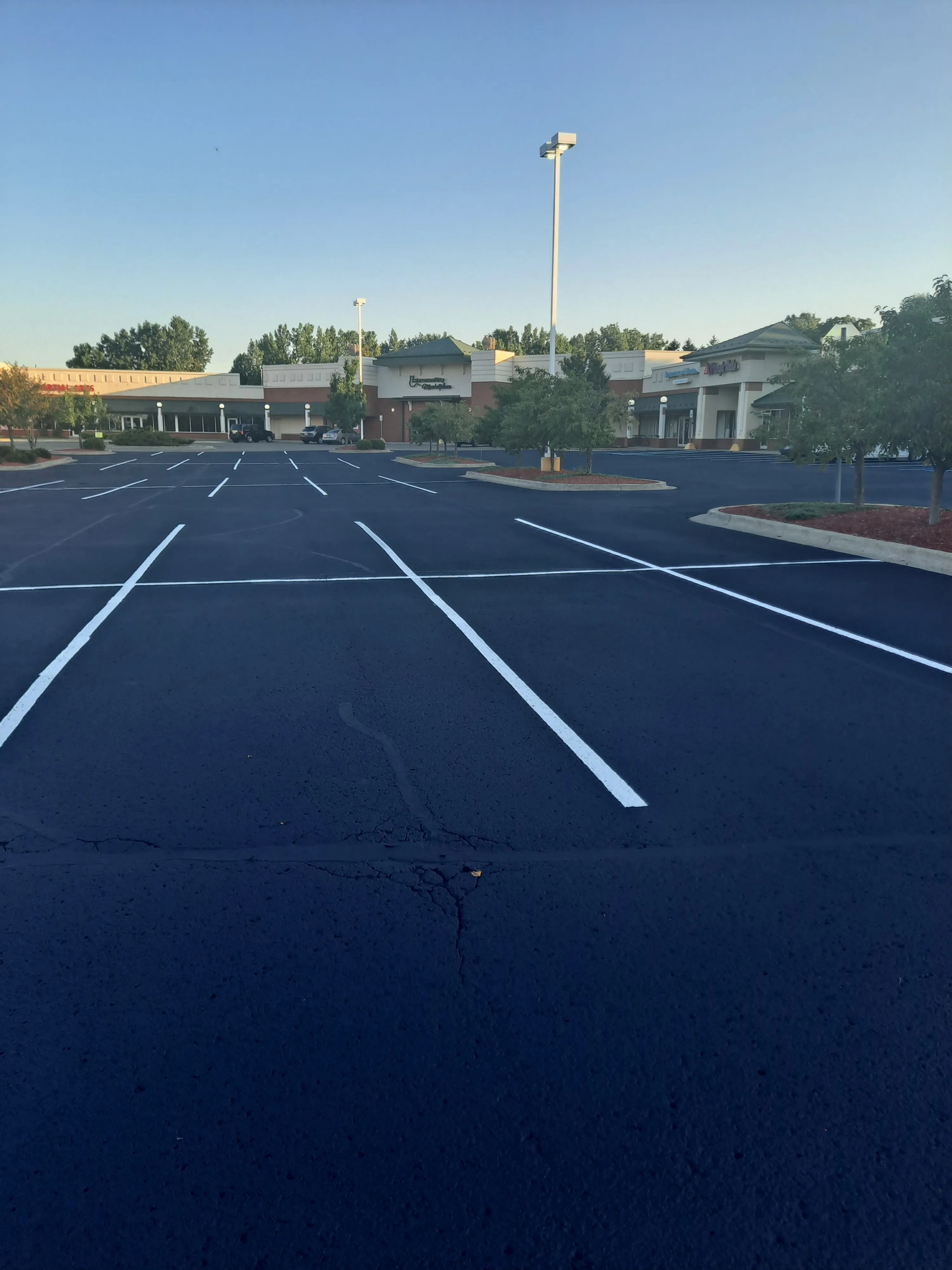 Freshly sealcoated parking lot with bright new white line striping